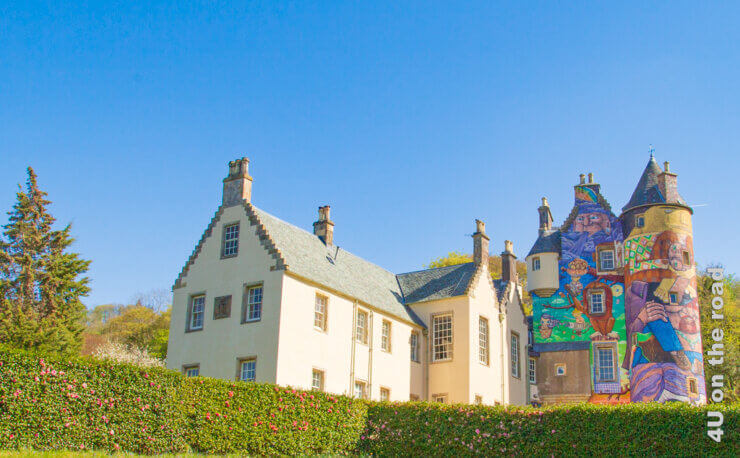 Das Featurbild zeigt das Kelburn Castle von der Gartenseite. Man sieht dan Anbau im Stil eines französischen Landhauses und die Front des alten Gebäudeteils mit Turm.